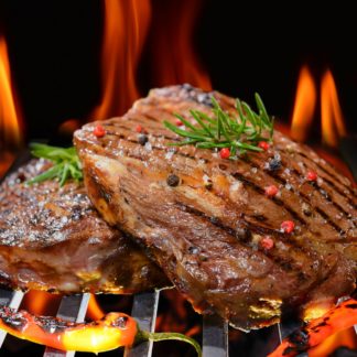 Grilled beef steak with vegetable on the flaming grill