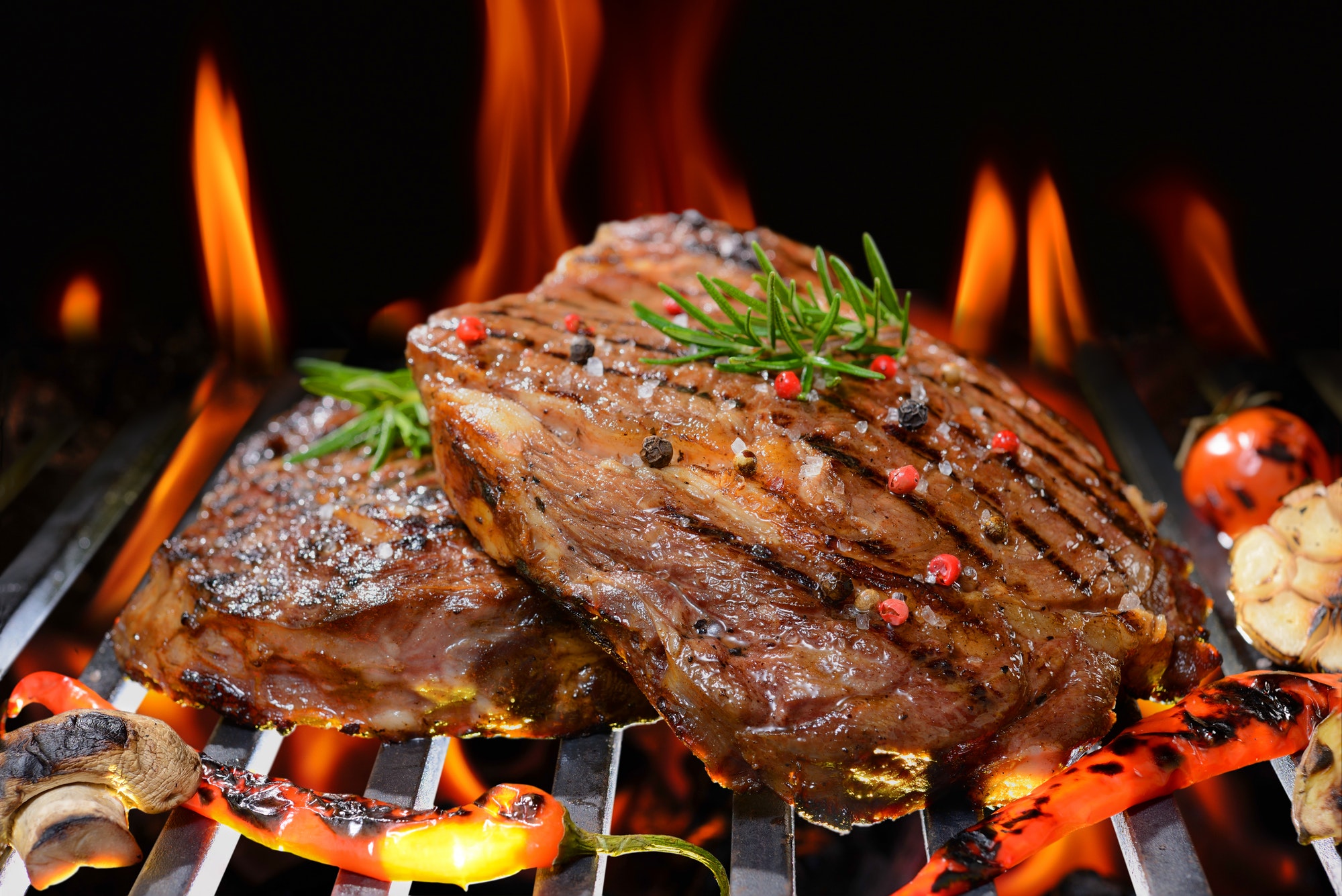 Grilled beef steak with vegetable on the flaming grill